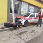 Taxista pierde el control y le pega a una motocicleta en el centro