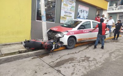 Taxista pierde el control y le pega a una motocicleta en el centro